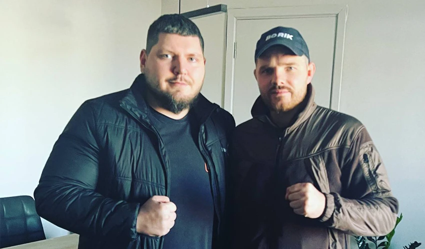 Michael A. and Vladimir Borisenko, the mayor of Boryspil, standing side by side in an office, each with a raised fist